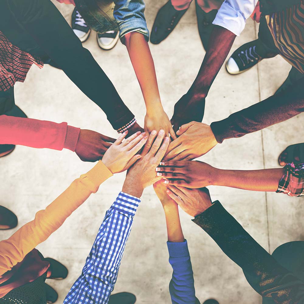 people in circle joining hands